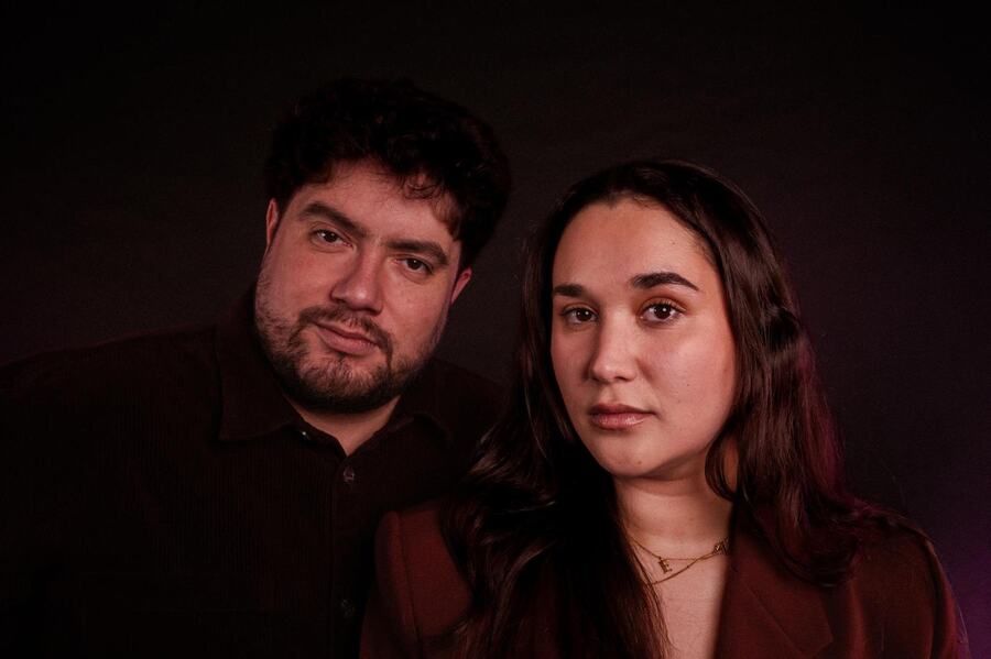 Ema en Andrés naast elkaar in donkerrood licht